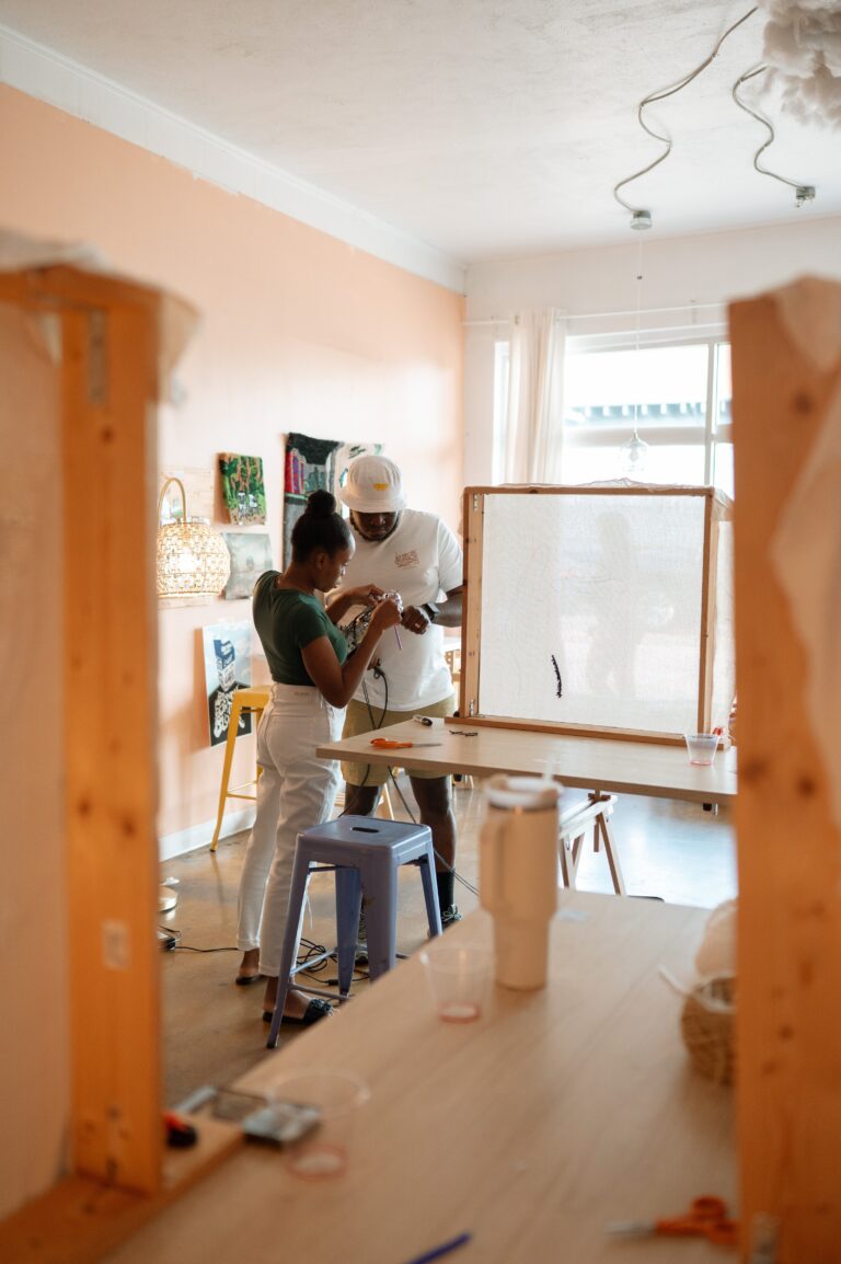 Workshop guests tufting at wooden frames in a bright studio